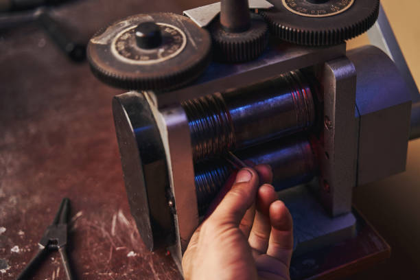 istock Jeweler working on metal piece on rolling mill 1326921953