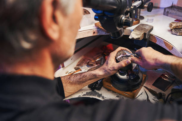 istock Man bringing burnisher to gem in ring during jewelry work 1326921954