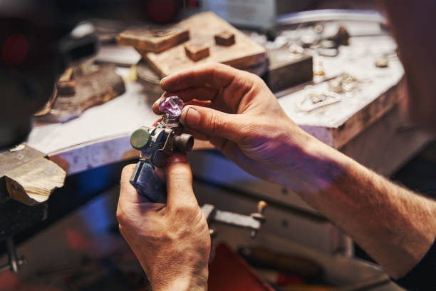 istock Male jeweler turning amethyst on gem-cutting tool 1326921967