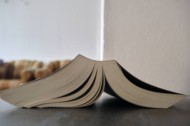 istock A thick book standing on wooden and black table together with blurred wall 1326922644