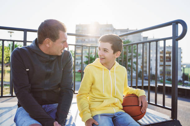 Morning Training. Father And Son Playing Basketball. Conversation between father and a son stock photo