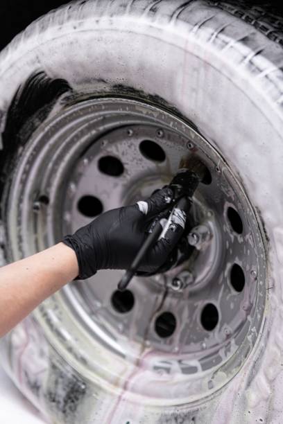 istock Detailing studio worker cleaning sport classic car wheel with brush 1326923706