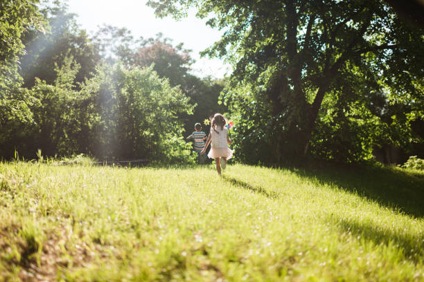 Small group of carefree children having fun while running in nature. Blurred motion.
