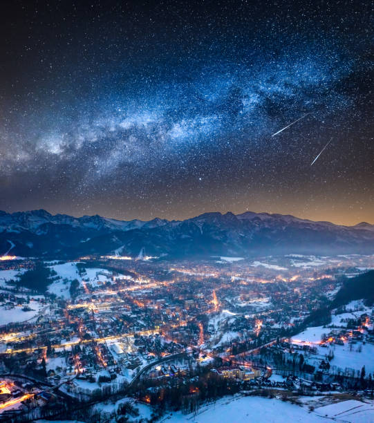 milchstraße und beleuchtete zakopane im winter in der nacht - poland mountain tatra mountains giewont stock-fotos und bilder