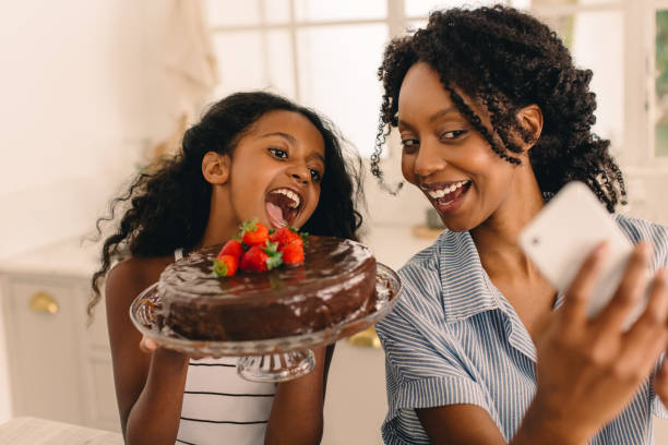 Waitress serving birthday cake to mother and daughter - Stock Image -  F033/5627 - Science Photo Library