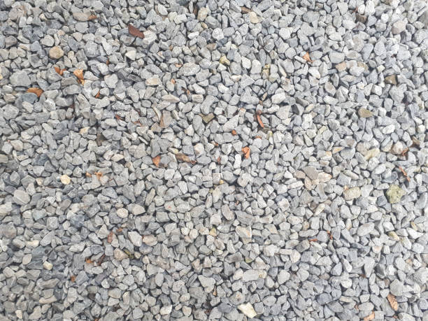 istock Gravel texture. Pebble stone background. Light grey closeup small rocks. Top 1326925553