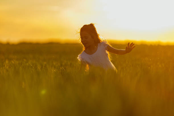 istock Little girl playing in wheat field 1326925899