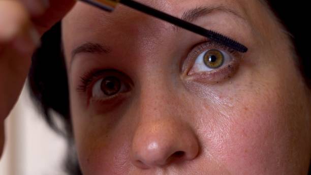 istock Woman paints eyelashes with a brush 1326927882