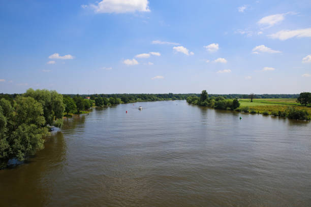 istock Panoramic view on typical dutch rural landscape with river maas and green agricultural fields in summer against blue sky near town Well, Limburg, Netherlands 1326930100