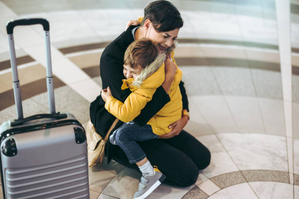 Mother getting emotional with her child at airport Mother getting emotional with her child at airport. Mother and son meeting at airport. airport hug stock pictures, royalty-free photos & images