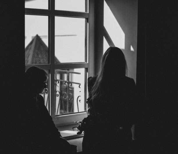 istock Two girls are sitting by the window. 1326934559