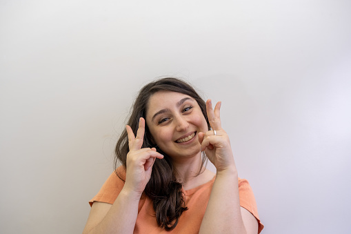 lady looking at camera in front of white background in her house with copy space pride proud victory success confidence prideful emotion portrait facial expressions concepts