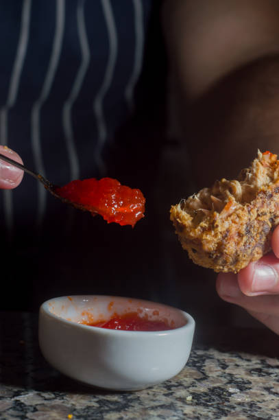 istock dumpling with hand putting red sauce with spoon on a marble table ,copy space 1326938335
