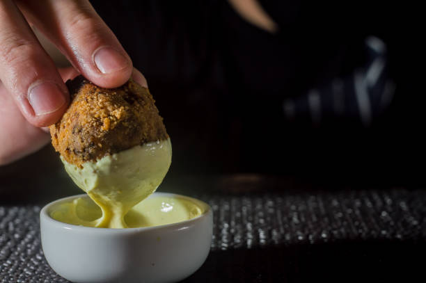 istock hand putting fried dumpling in a pot with mayonnaise ,copy space and dark background 1326938664