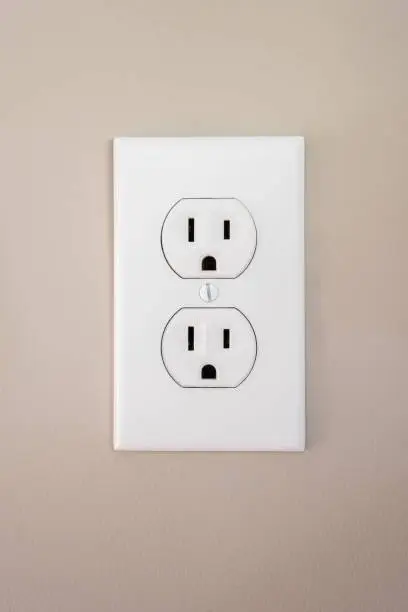 A 115 amp white wall outlet with a face plate