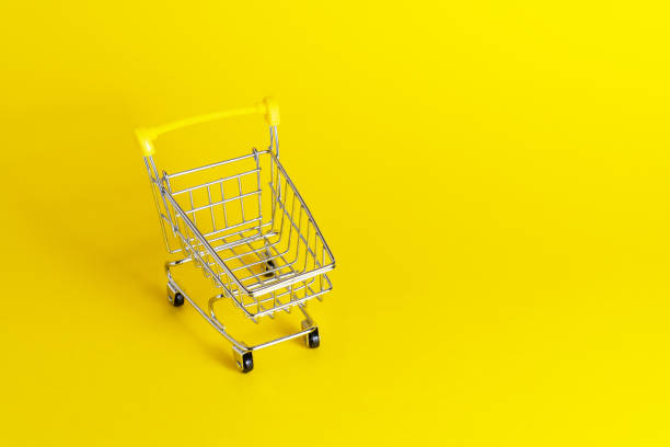 istock Empty shopping cart with yellow handle on cheerful yellow background with copy space. 1326942144