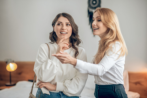 Apartment rent. Young woman talking with a real estate agent about renting an apartment and looking involved