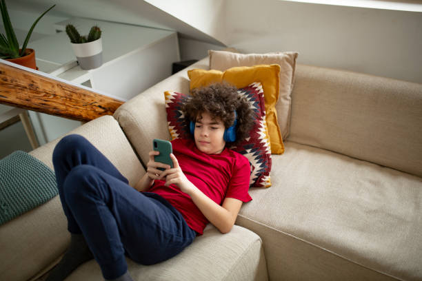istock High angle view of a young Caucasian boy using a smart phone at home 1326945314