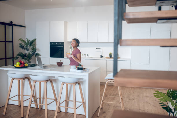 istock Young mulatta in the kitchen watching something on internet 1326946254