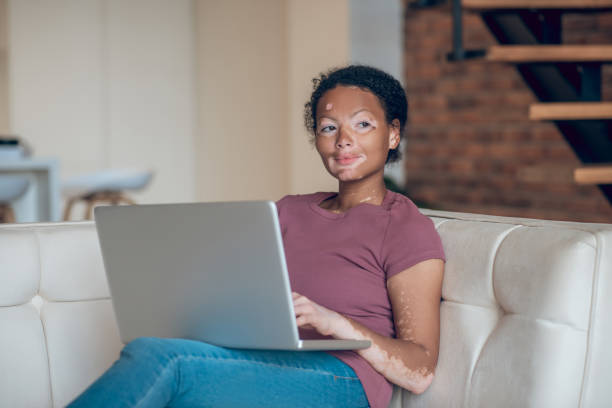 istock Cute young woman working on a laptop and looking thoughtful 1326946306