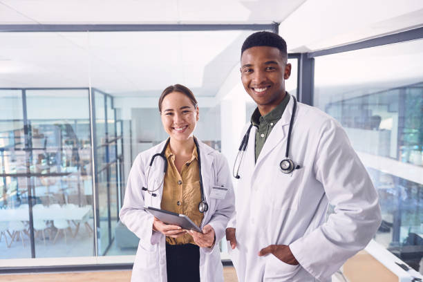 istock Cropped portrait of two young doctors working on a digital tablet while standing in the hospital 1326946922