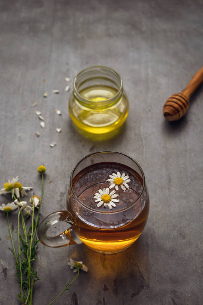 istock Chamomile flower tea in a glass cup and honey on a rustic table 1326947920