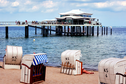 Japanese style pavilion with stalls on a pier in Timmendorfer Strand with beach chairs in the foreground in Timmendorf, Germany, June 12., 2021