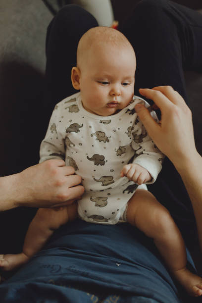 istock baby lies on daddy's lap 1326950612