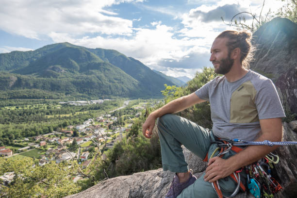 male mountain climber takes a break to enjoy the view - conquering adversity wilderness area aspirations achievement imagens e fotografias de stock