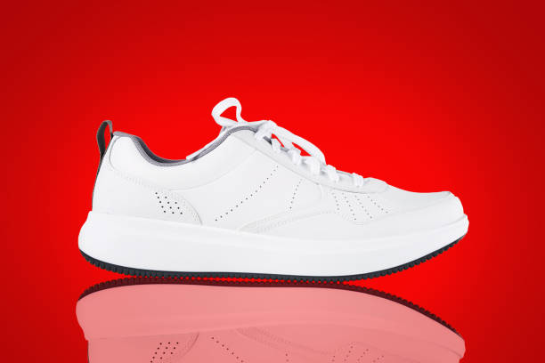 istock White sneaker isolated on red background. New unbranded sport shoe 1326951909