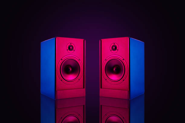 istock Two stereo speakers with neon light on dark background 1326951910