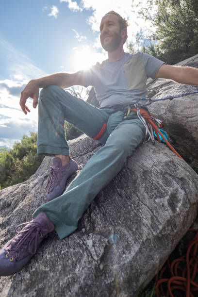 male mountain climber takes a break to enjoy the view - conquering adversity wilderness area aspirations achievement imagens e fotografias de stock