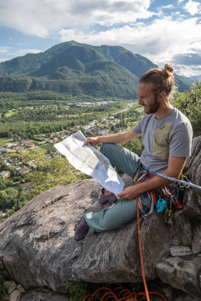 male mountain climber reads a map - conquering adversity wilderness area aspirations achievement imagens e fotografias de stock