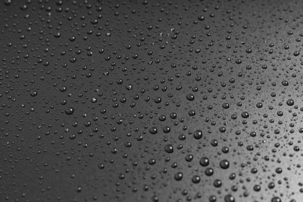istock drops of water on a black background. dew on the surface. 1326955198