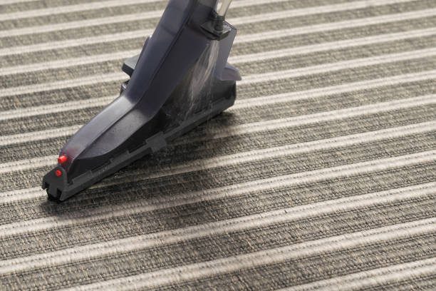 istock vacuum cleaner brush cleans striped carpet, close-up 1326957734