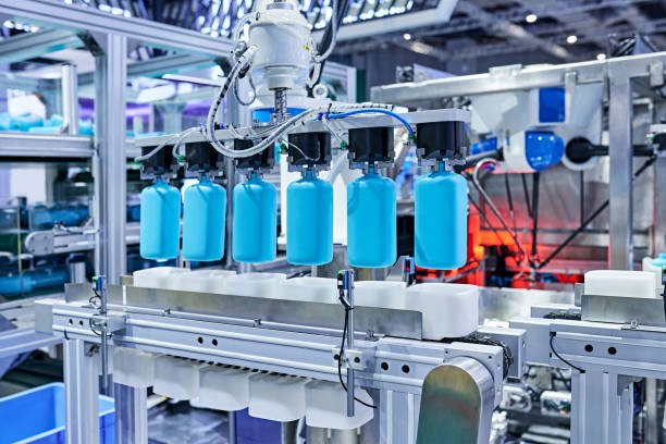 istock Robot Arm Gripping Bottles at Production Line 1326958943