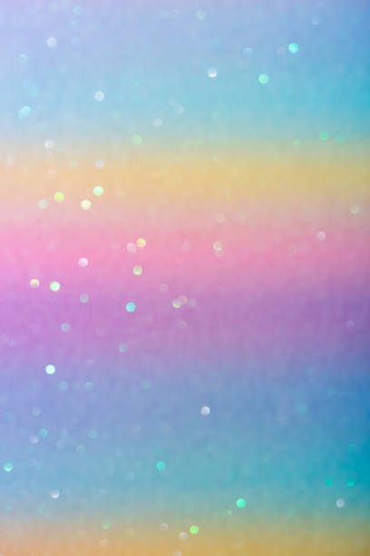 istock Photo of a rainbow-colored paper surface with glitter. Abstract blurred multi-colored pastel background with sequins 1326961190