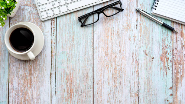 istock Top view wooden table coffee mug keyboard glasses notebook place copy space. 1326961239