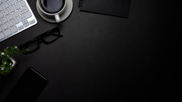 istock Black background office desk with smartphone coffee in office. Top view 1326961259