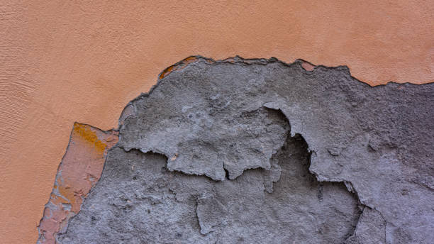 istock Surface of crumbling cement wall plaster and brown paint. 1326961515