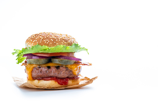 Cheeseburger Burger Hamburger with cheddar cheese and bacon, salad, onion, pickles and tomato isolated on white background