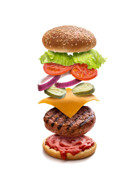 istock Burger layered ingredients as explosion flying open bun isolated on white 1326962640