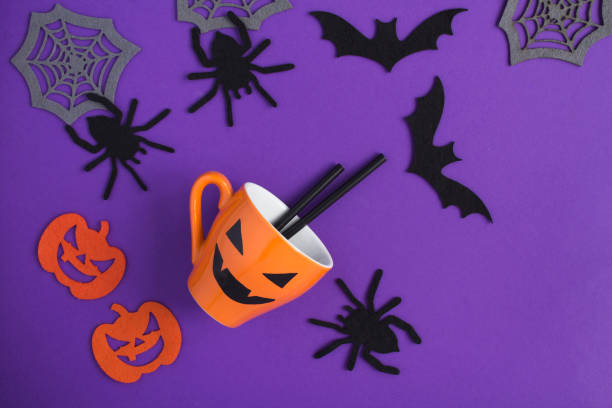 istock Composition  for Halloween with orange cup, decorative spiders, pumpkins, spider webs and bats on the purple  background 1326963433
