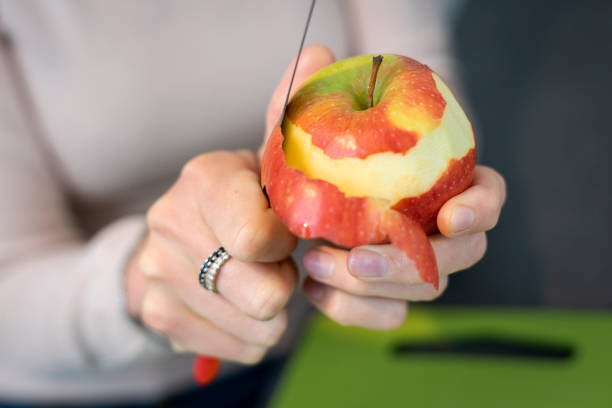 istock Close-up of hands peeling an apple. 1326963523
