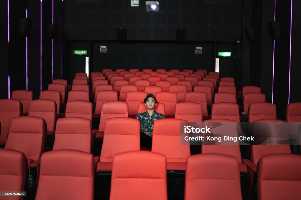 Asian Chinese teenager alone in cinema watching movie Movie Theater Stock Photo