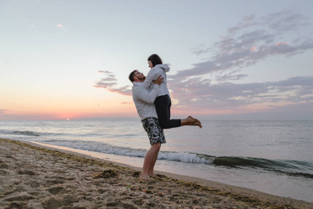 istock couple hugging look at sunset above sea 1326964753