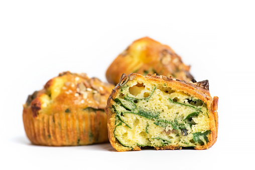 Homemade oven baked savory Muffins with eggs, spinach potatoes and cheese on white background. Healthy food concept.