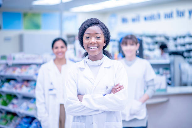istock Smiling African female pharmacist with her team 1326968566