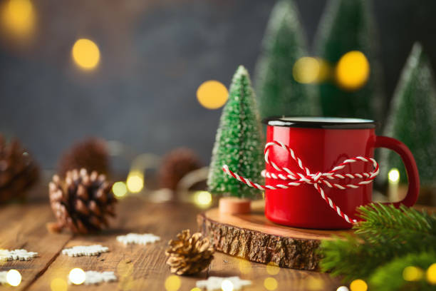 istock Red coffee cup and Christmas decorations on wooden table with bokeh lights 1326968743