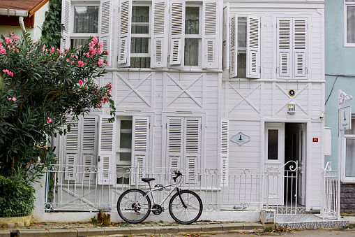 An old white building with a bike parked. Streets of the island of Buyukada. Istanbul, Turkey - 07.28.2017